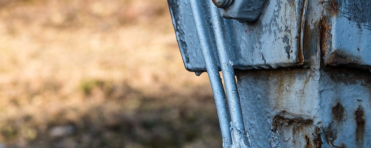 Earth conductors clamped to the foot of a lattice transmission tower leg and running into the concrete foundation