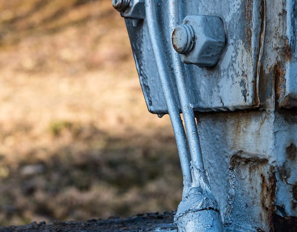 Earth conductors clamped to the foot of a lattice transmission tower leg and running into the concrete foundation
